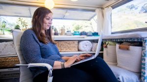 Woman works on computer in her RV